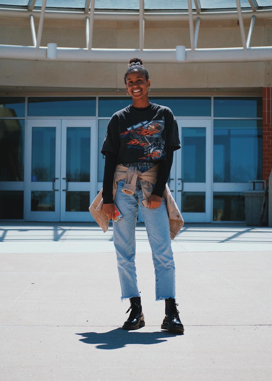 woman in black crew-neck shirt, blue denim jeans and black leather shoes standing near white painted building photo – Free Sioux center Image on Unsplash